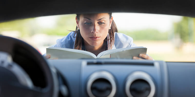 woman looking at car book